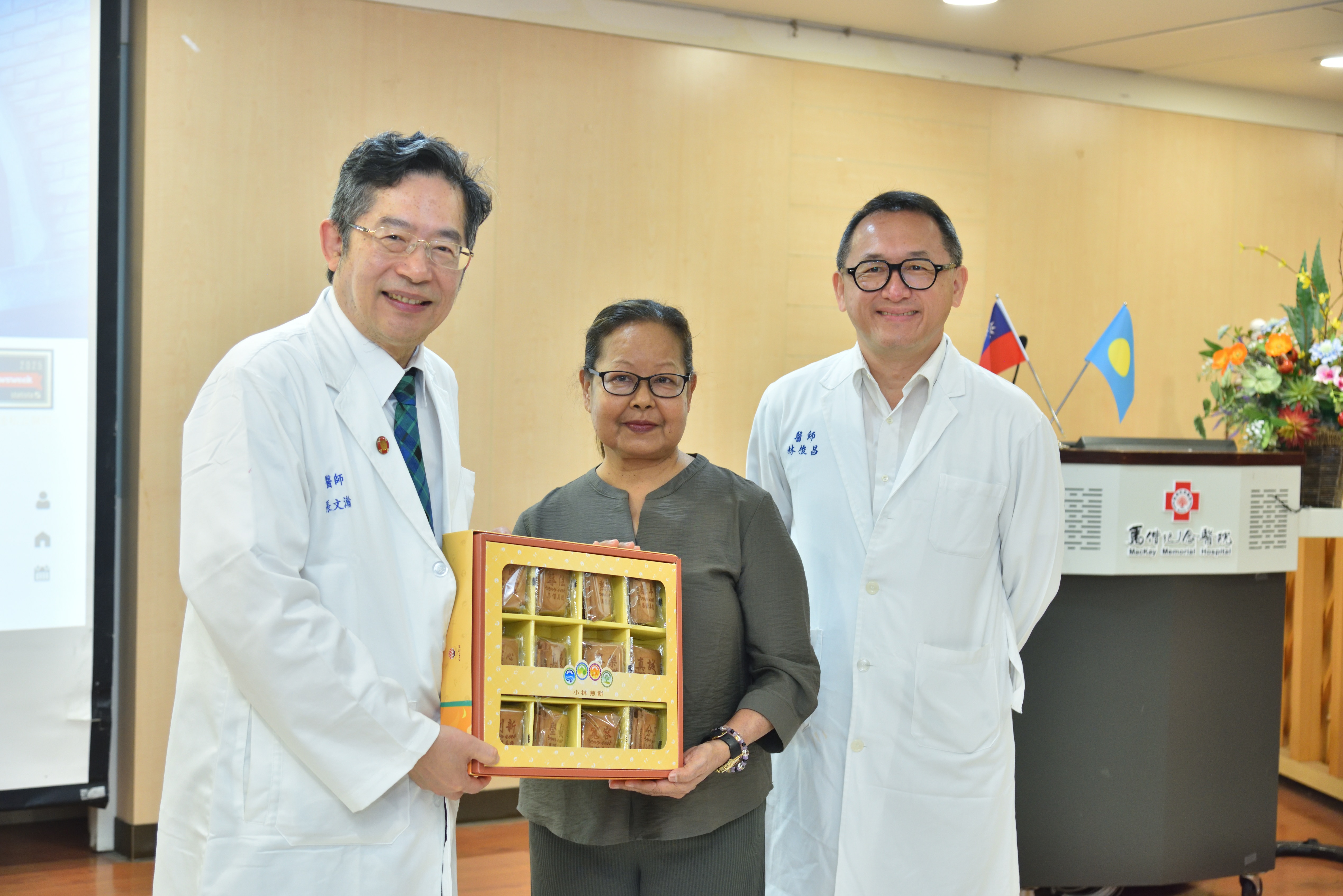 帛琉首例轉診活體換肝記者會-馬偕紀念醫院總院長張文瀚(左)、一般外科林俊昌醫師(右)致贈禮物給米德莉(中)